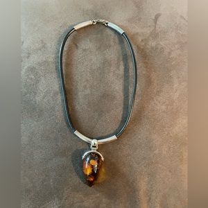 Amber pendant necklace, on black leather and silver accents. Beautiful piece.